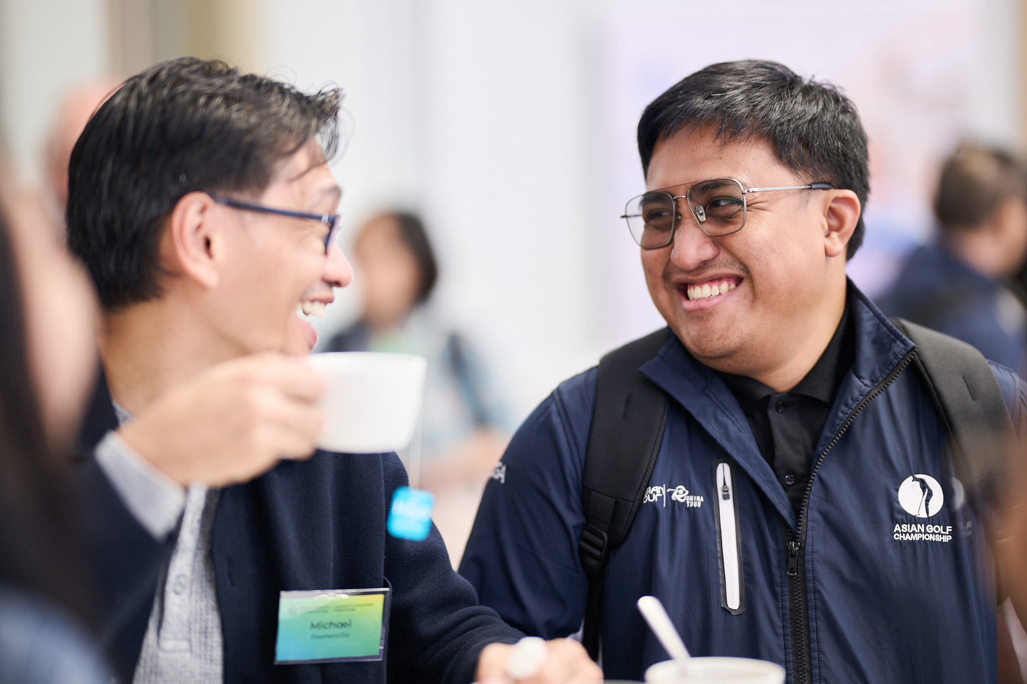 Two men sat smiling and chatting.