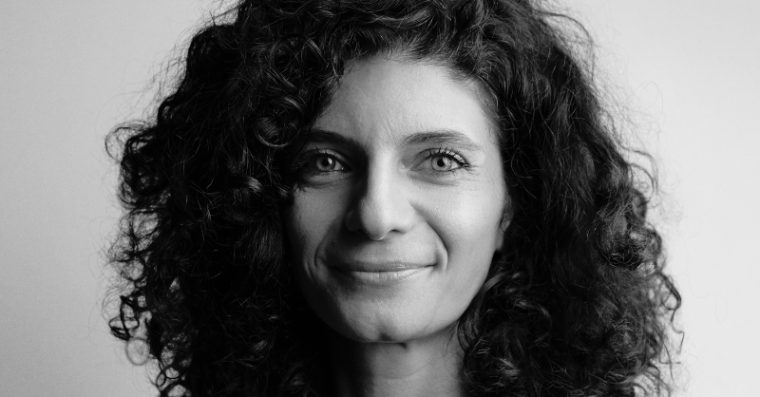 black and white image of Hub Member Emanuela. Looking into camera and smiling