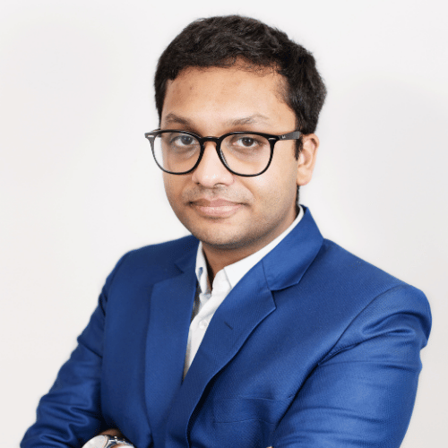 Atif Syed, facing the camera in a blue suit with open shirt